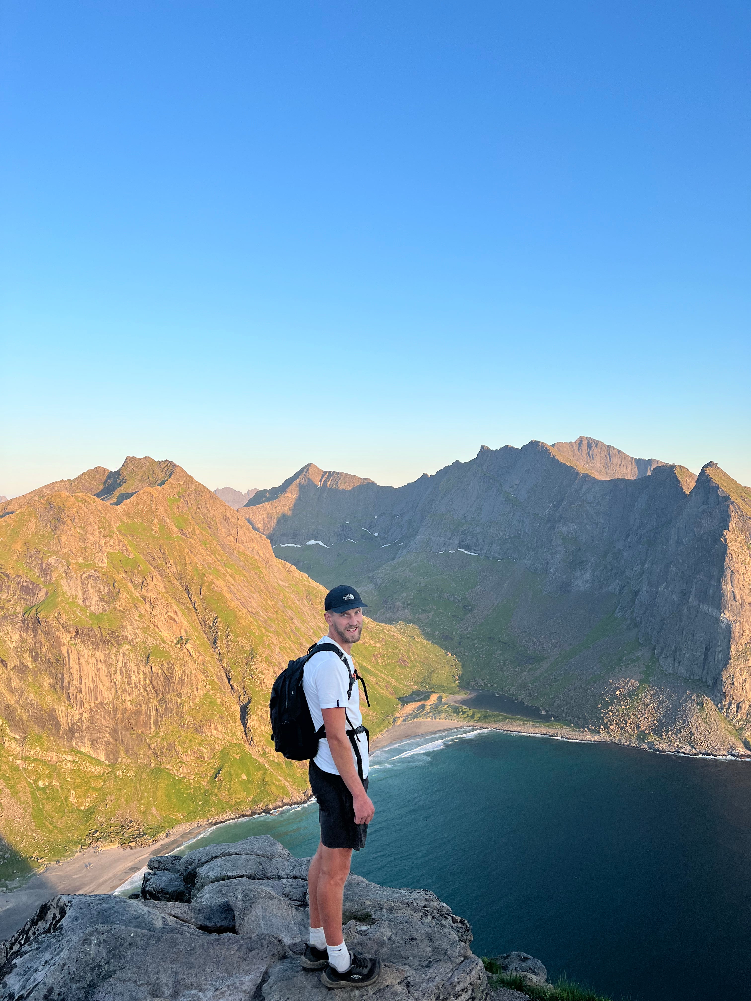 Harry smiling while looking over mountains and a beach in Norway