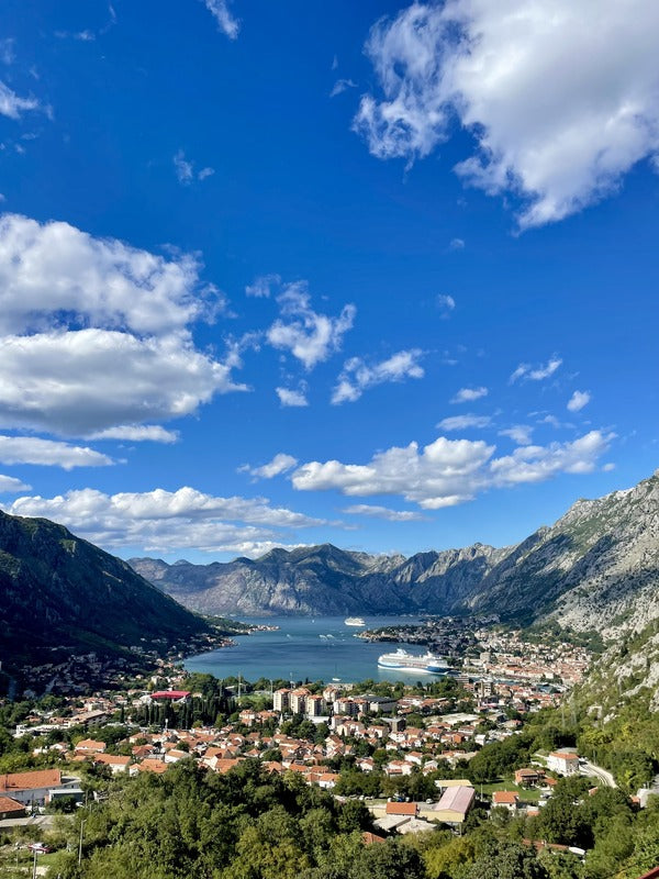 bay of kotor with houses in the foreground and mountains in the background